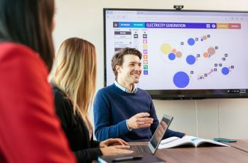 CER staff members in discussion with data visuals in the background