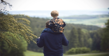 Boy rides on man’s shoulders
