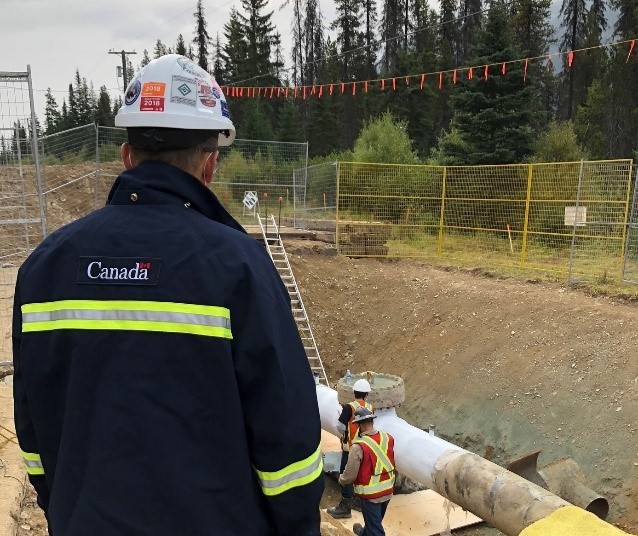 Figure 4 – A CER Inspector observes work on a section of pipe at a Trans Mountain site, near Jasper, Alberta.