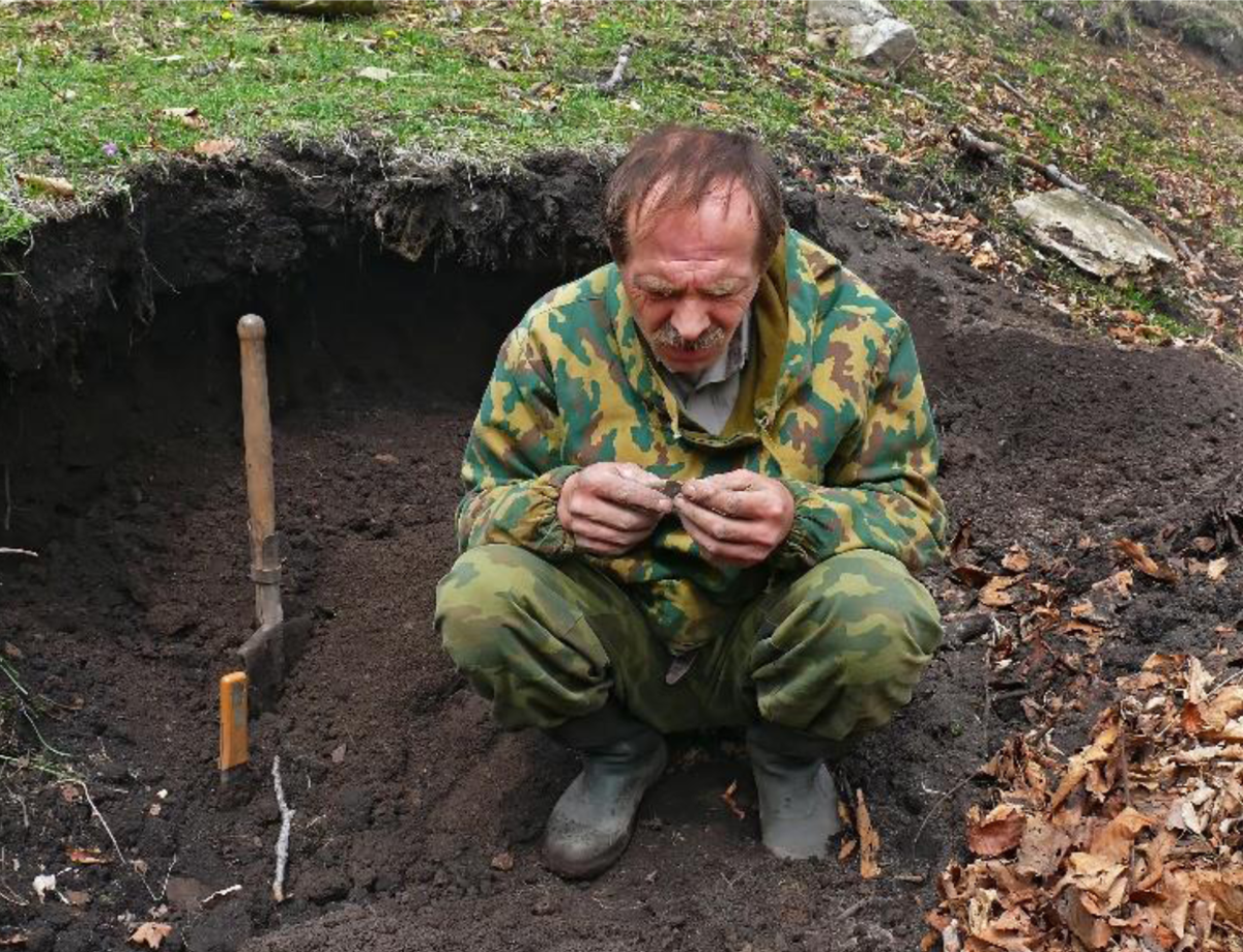 Figure 6 – Un homme examine un objet découvert lors d'une fouille.