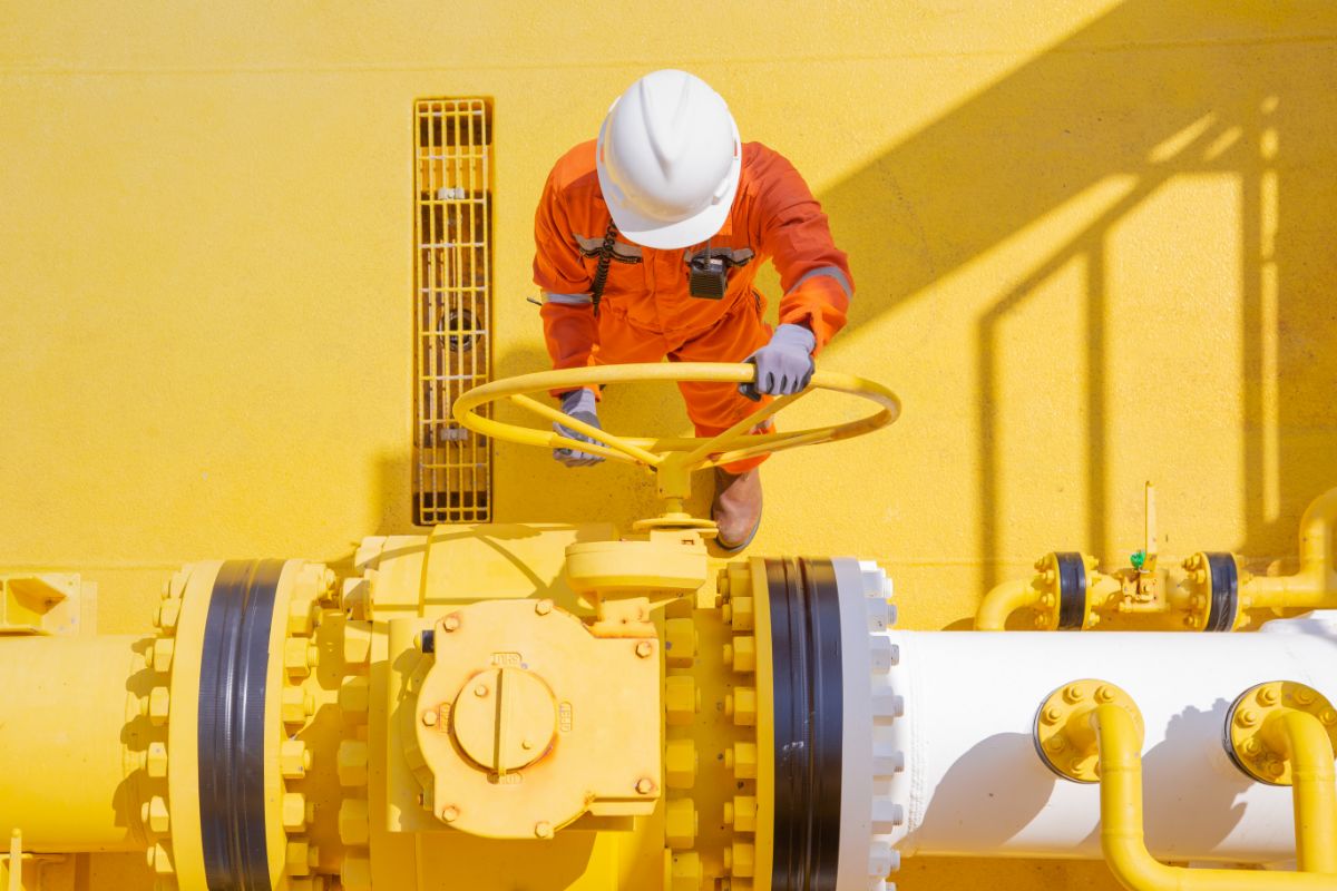 Worker turning pipeline valve.