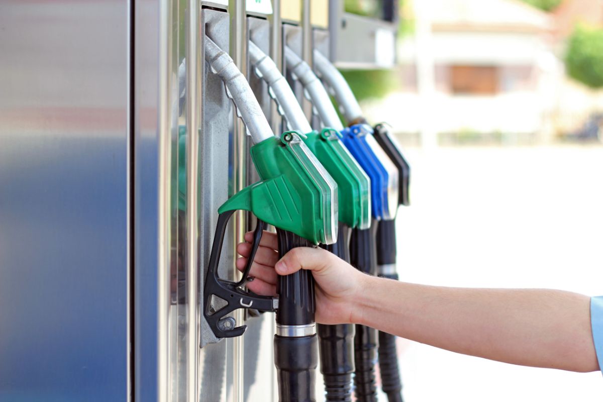 Hand removing gas pump from row of pumps.