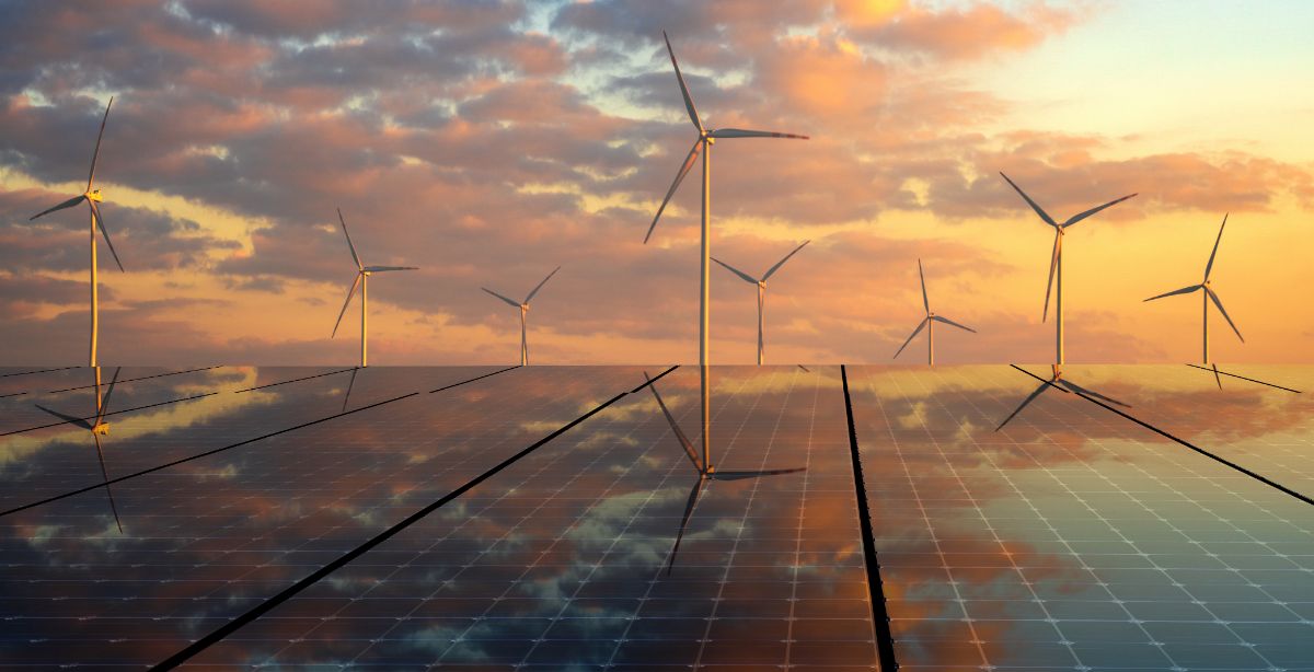 Wind turbines behind solar panels.