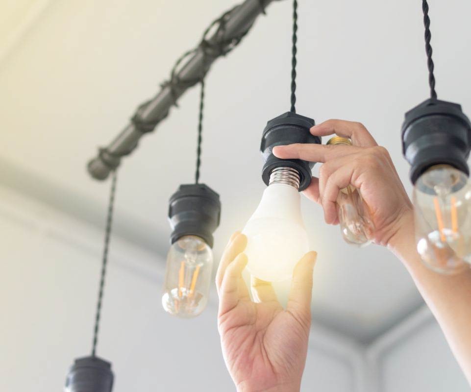 Hands change LED lightbulb.