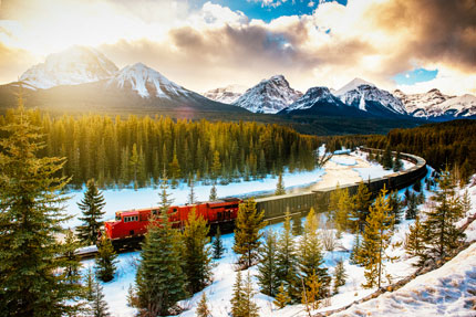 Long train de marchandises qui serpente dans les Rocheuses un jour d’hiver